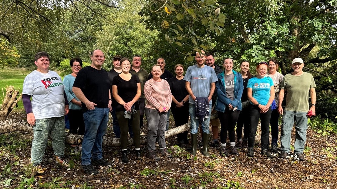 Parks volunteers stand next a tree