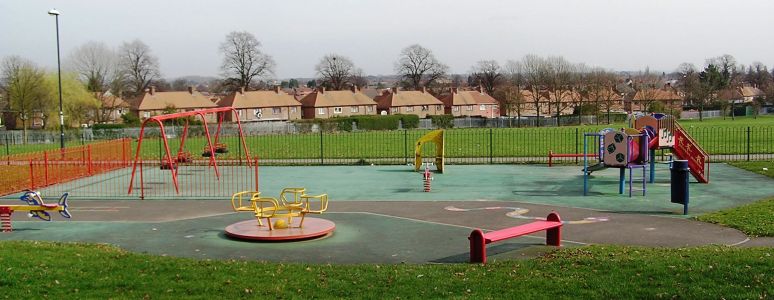 Photograph of classic play area at Osmaston Park with roundabout, slides and swings