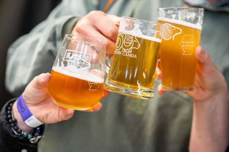 Three people cheersing with beers