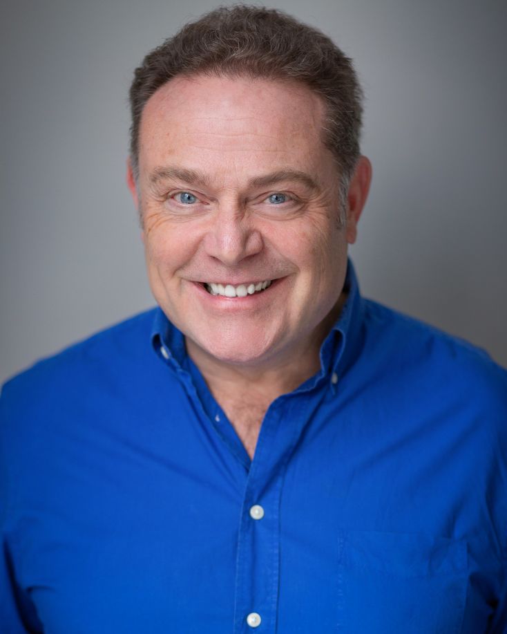 Actor John Thompson smiling in a mid shot.