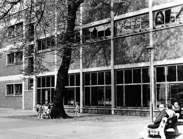 outside a building, men and women sat on benches relaxing