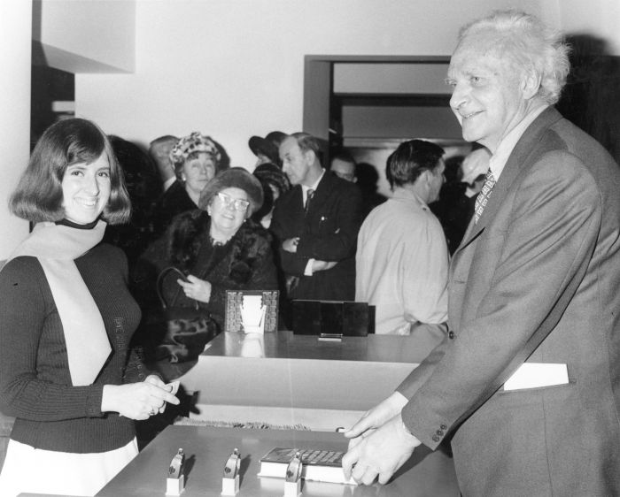 women getting a book and a man passing over the book in the library
