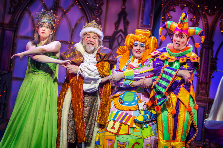 Four panto characters in bright costumes linking hands.