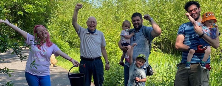 image shows lots of happy people with buckets from cleaning 