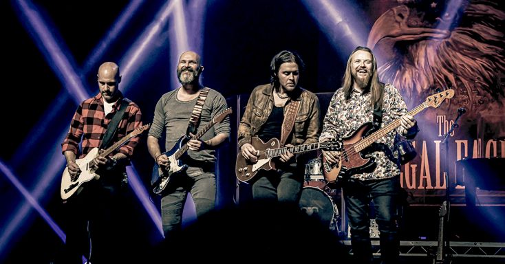 Illegal Eagles line up playing guitars